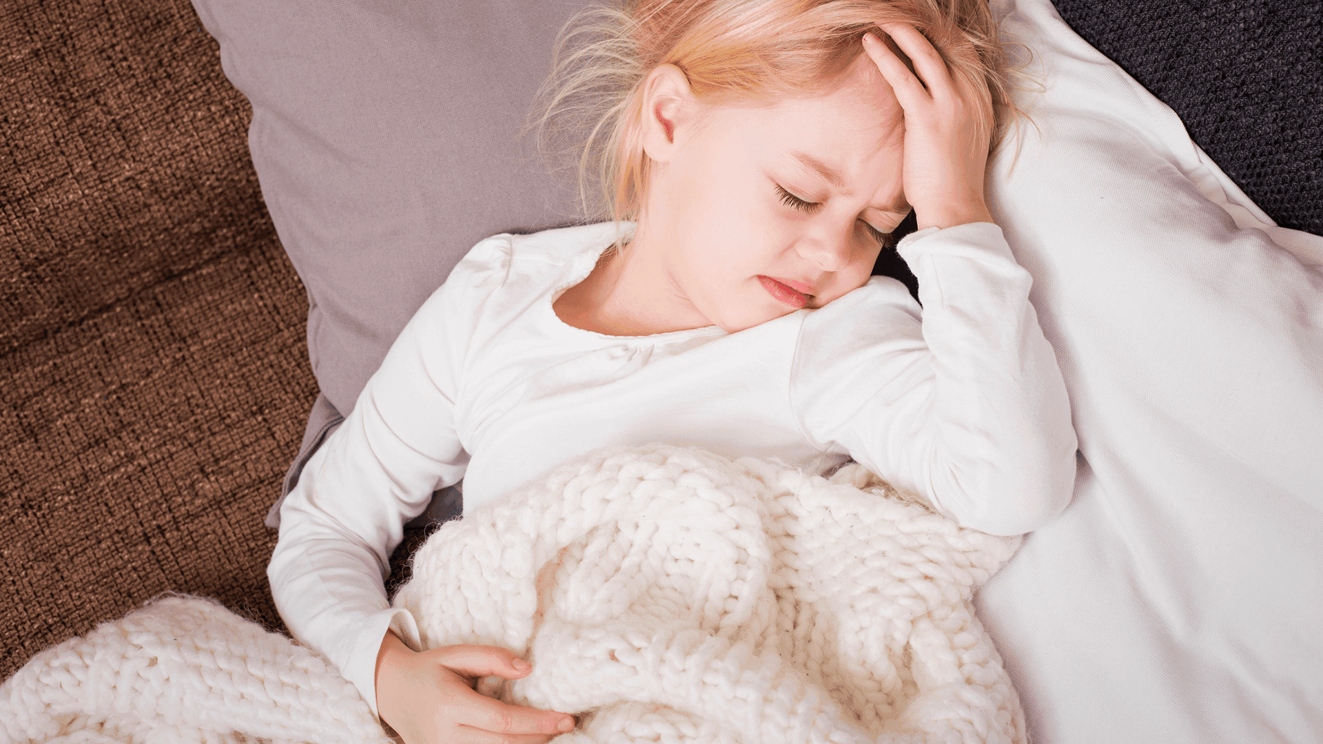 young child with hand on head