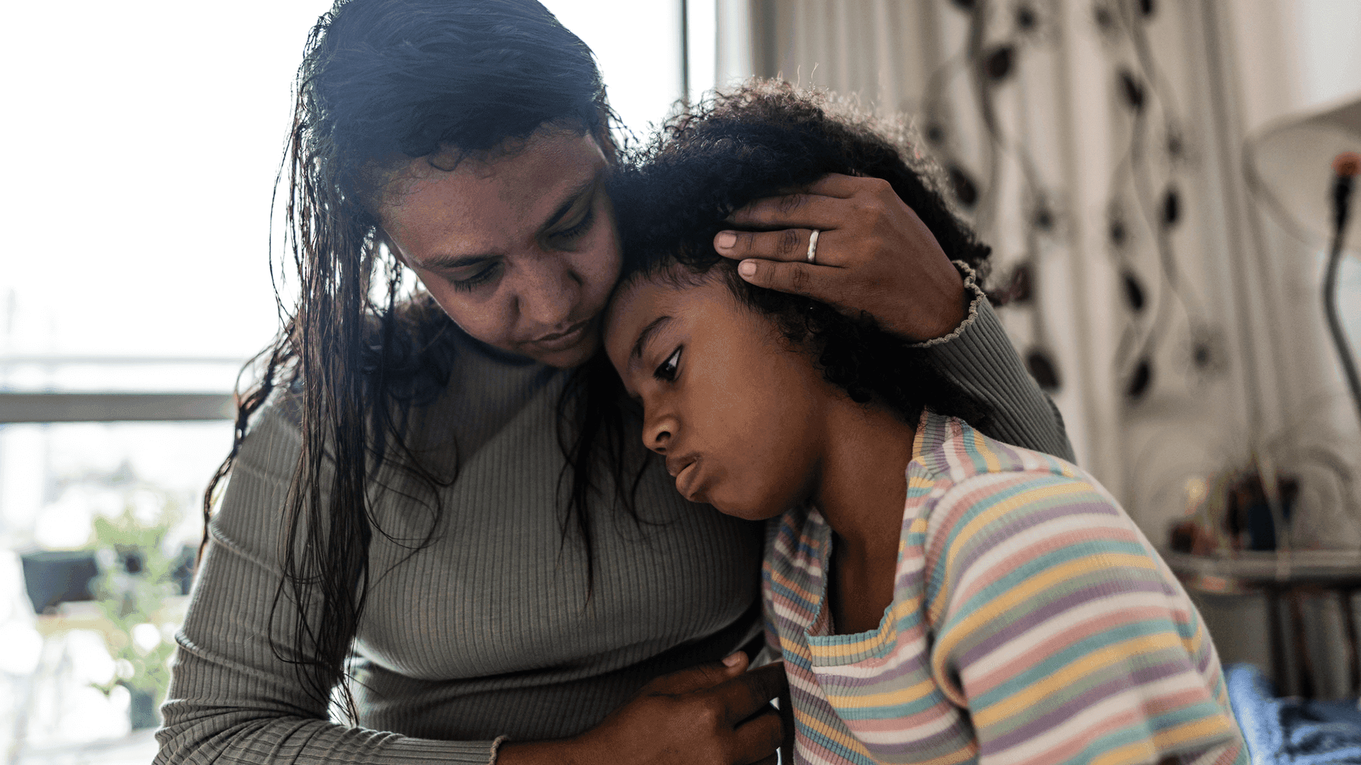 Mother comforts her young daughter