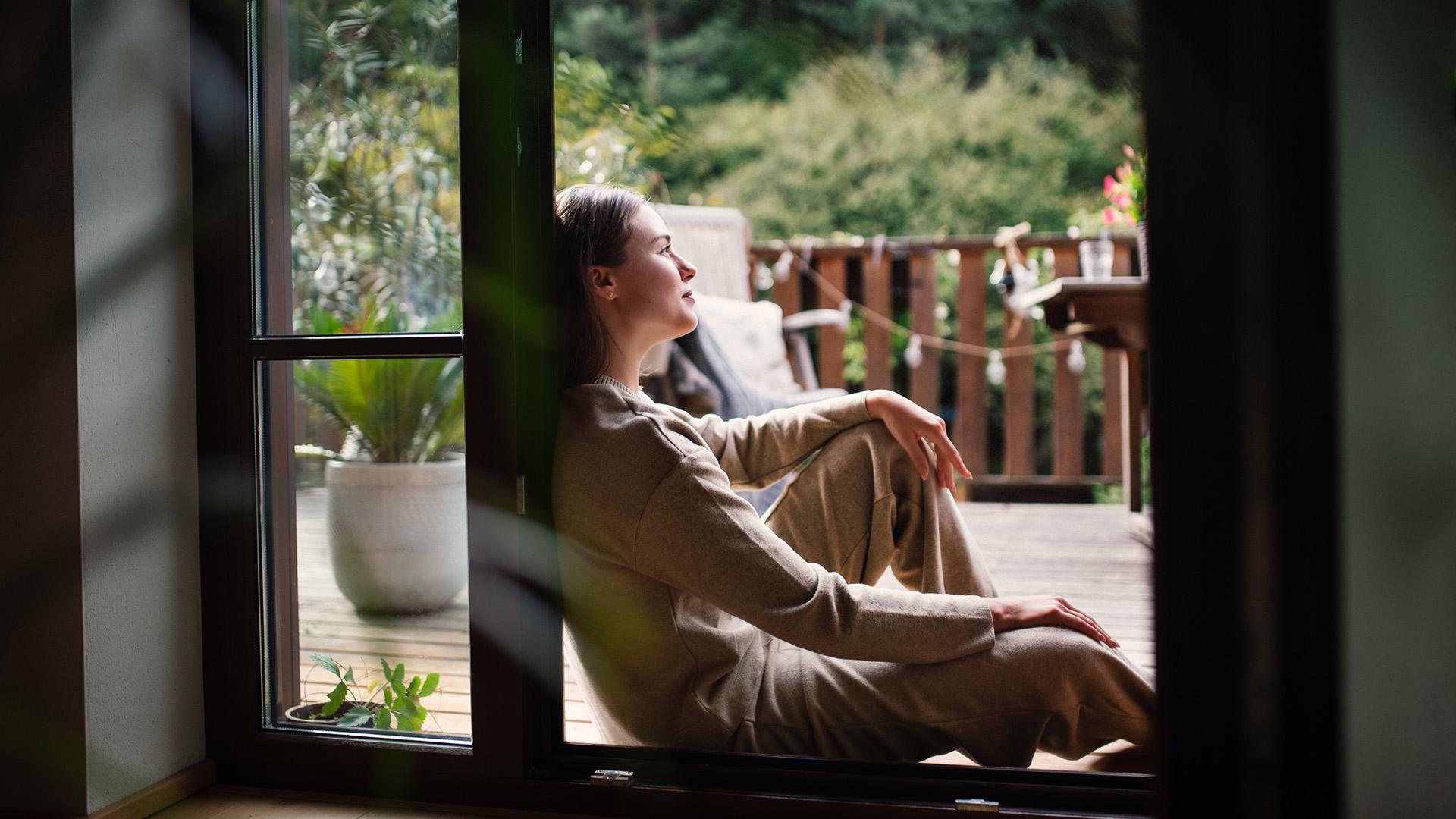 Woman resting in doorway of balcony doors