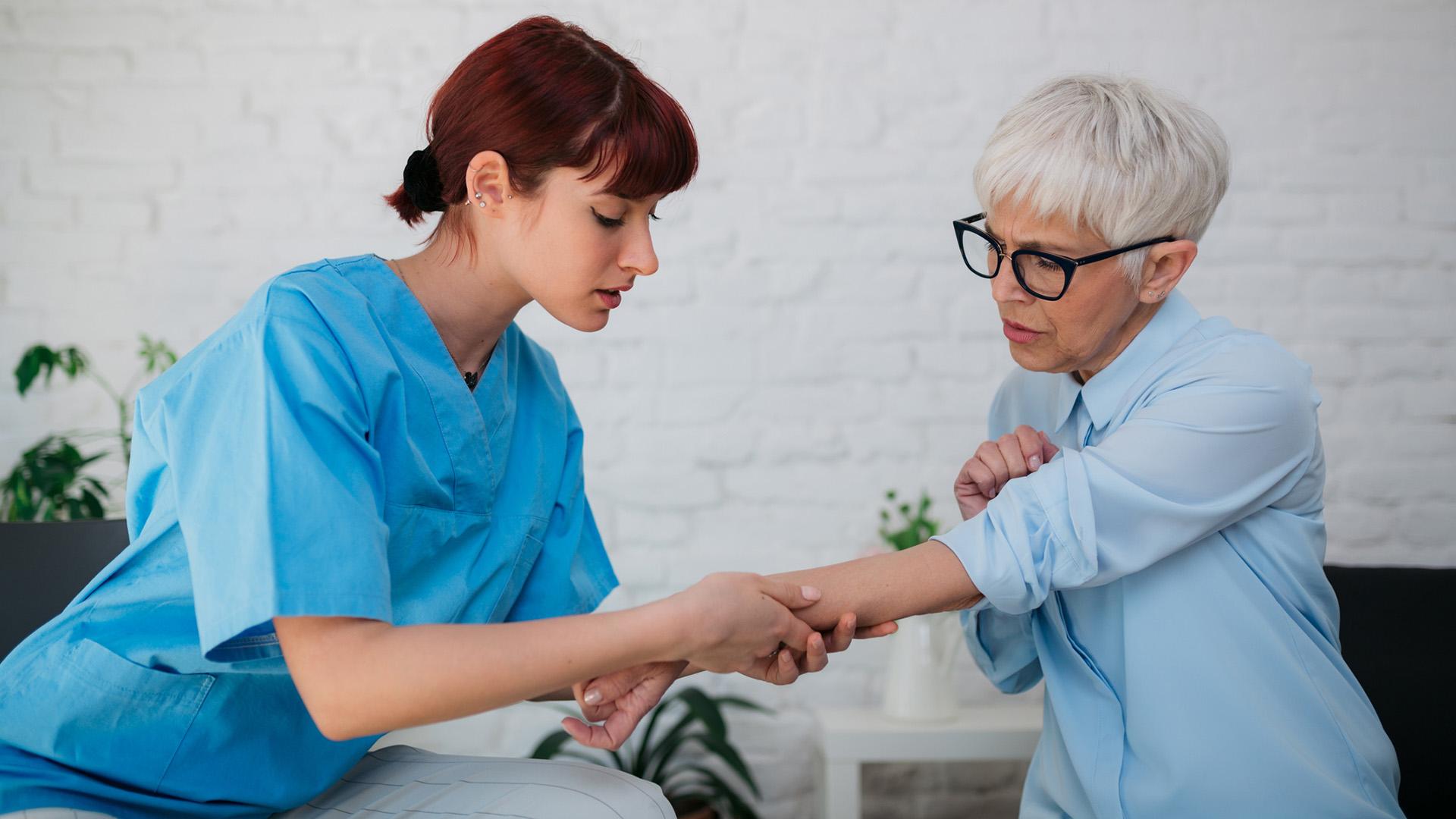 Young adult female nurse in a home visit of an elderly female patient